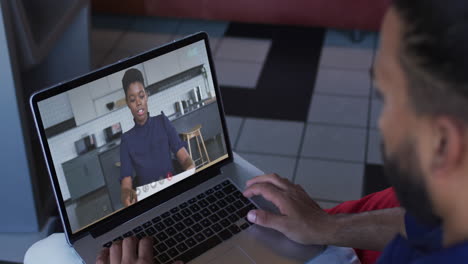 middle eastern man having a video call with female colleague on laptop