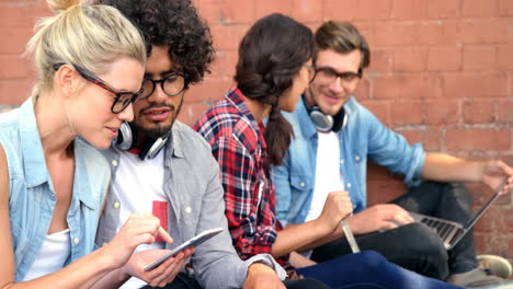 amigos que usan teléfonos inteligentes y portátiles