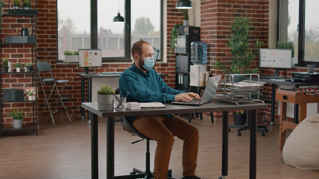 Man celebrating success in the office with mask