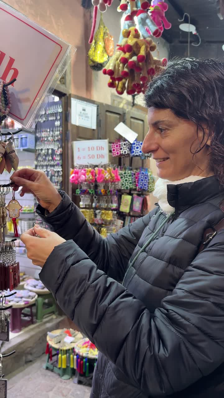 Mulher a Ver Chaveiros e Lembranças numa Banca de Mercado
