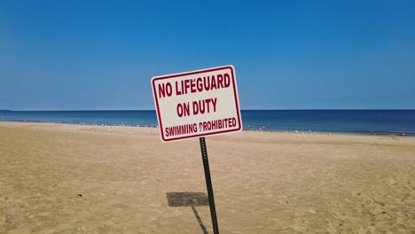 no lifeguard on duty sign on an empty beach in new york