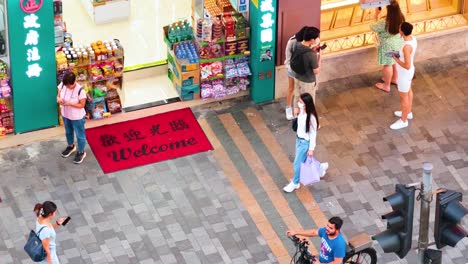 pedestrians pass by a busy hong kong shop