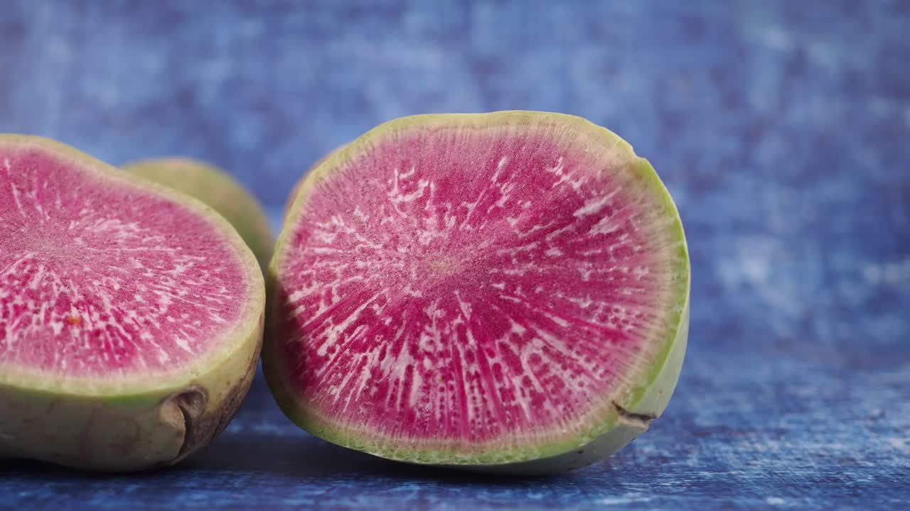 Metà di ravanelli anguria rosa vivace su sfondo blu