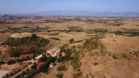 Toma-De-Paisaje-Con-Drones-De-Un-Terreno-Montañoso,-Se-Detiene-En-Una-Roca-Megalítica