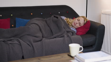 woman sleeping on couch with blanket