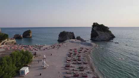 aerial: budva beach, montenegro, with loungers and tourists, sveti nikola island