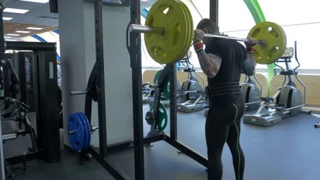 Man Performing Barbell Back Squat in Gym