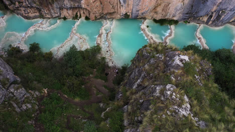 Beautiful-overhead-aerial-shot-zoom-in-with-a-drone-from-the-Andes-area-of-the-famous-turquoise-Lake-Millpu-located-between-mountains-in-the-afternoon-located-in-Ayacucho,-Peru