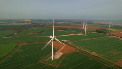 lissett airfield rotating wind turbine farm on agricultural farmland aerial rising view yorkshire countryside
