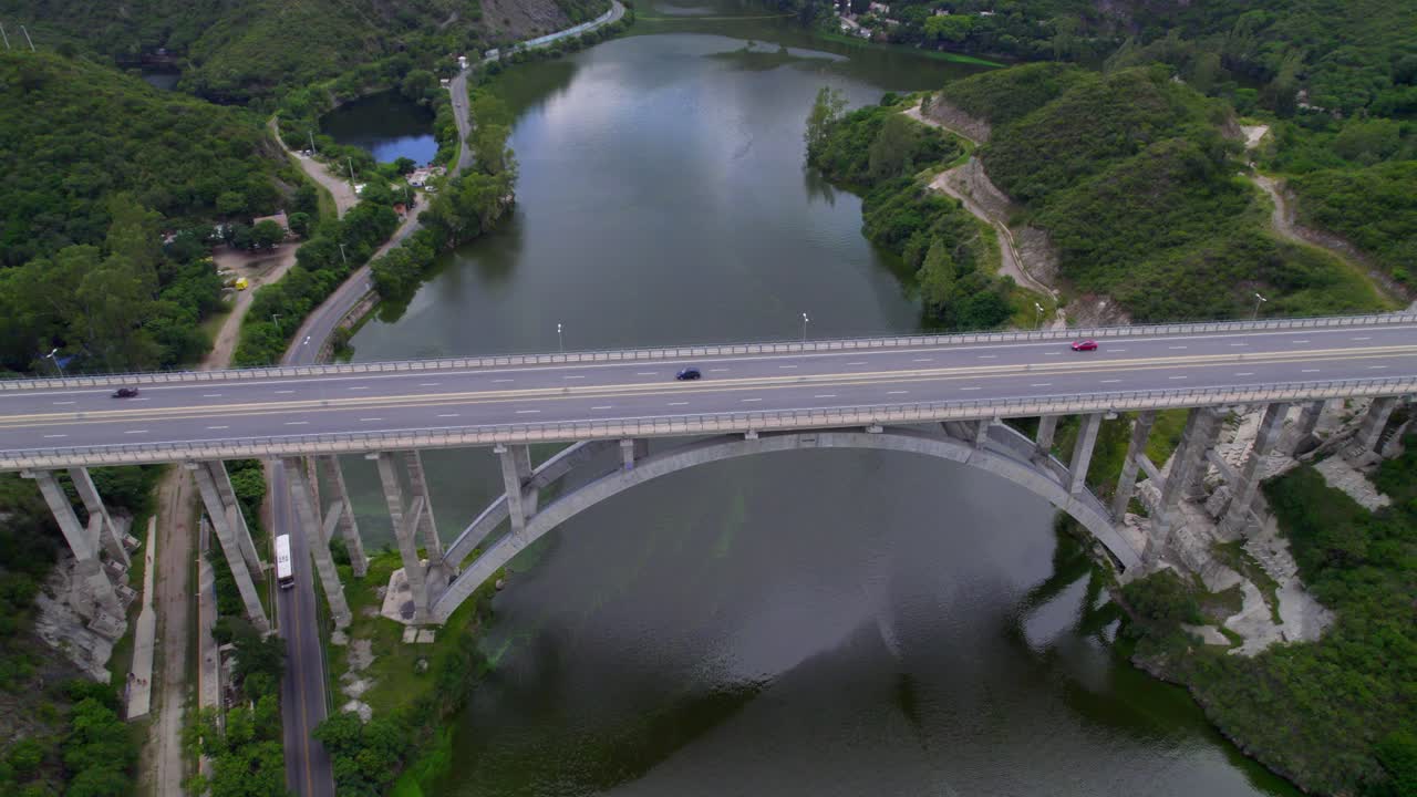 Aerial view of highway bridge over San Roque lake with cars moving on road. Argentina