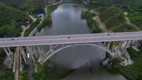 aerial view of highway bridge over san roque lake with cars moving on road. argentina
