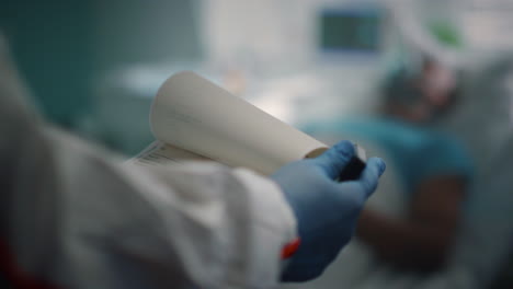 sick patient with oxygen mask lying bed. doctor checking medical history closeup