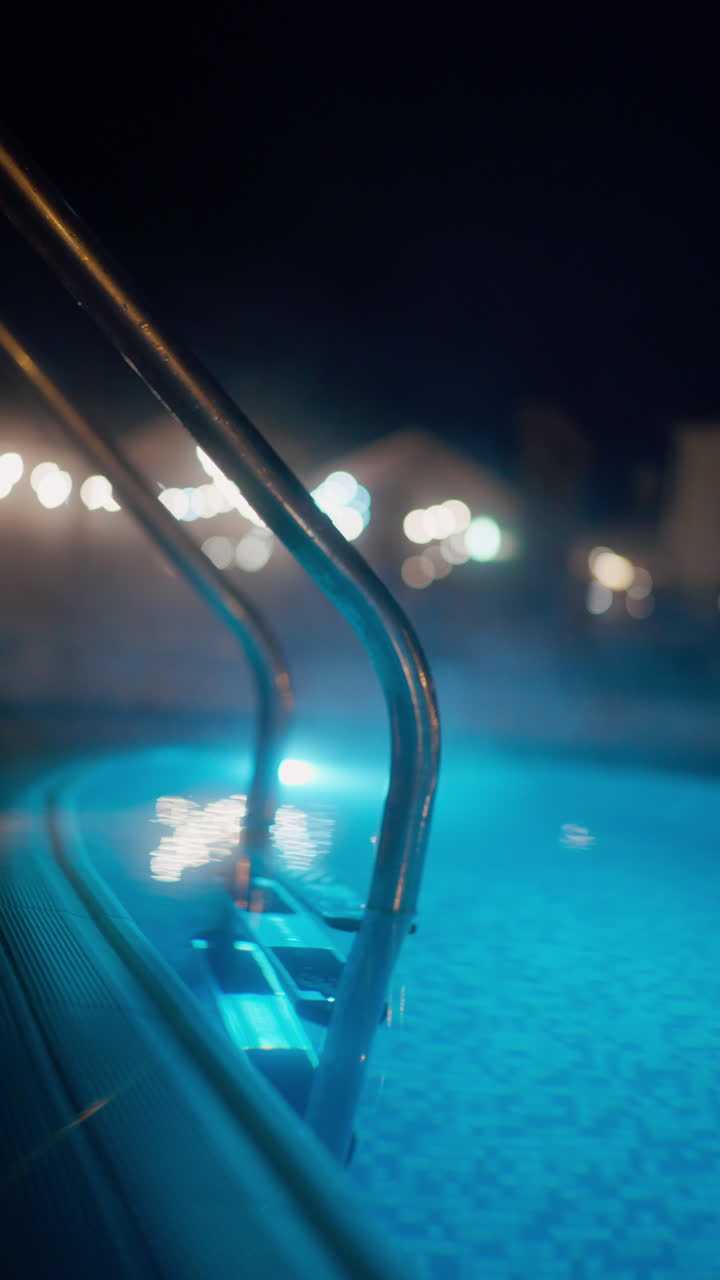Steaming Hot Tub with Blue Light and Handrail at Night
