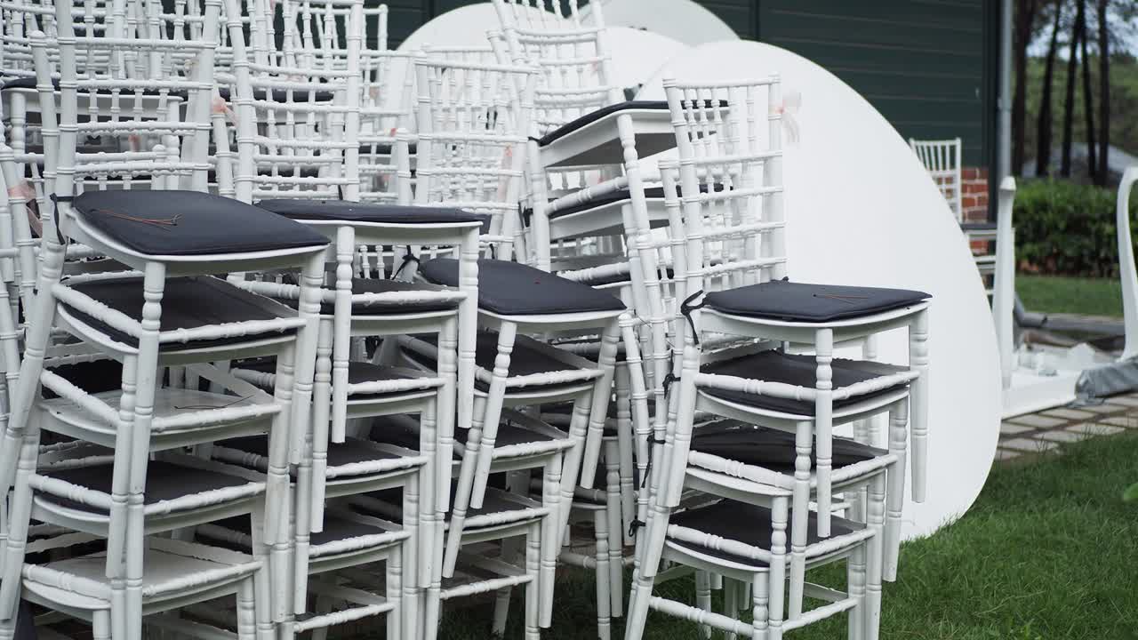 sillas blancas apiladas en un entorno al aire libre
