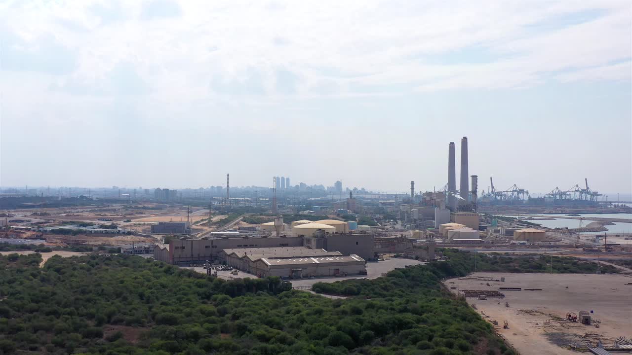 Aerial view of a large industrial complex with a power plant and port facilities