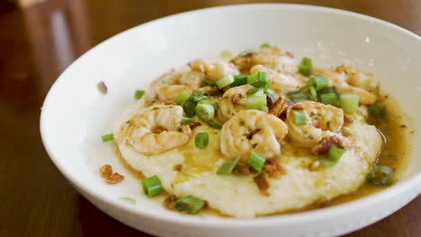 steaming delicious plate of homemade shrimp and grits in a bowl ready to eat - dynamic isolated motion