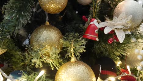 close-up pan across a decorated christmas tree revealing beautiful red, white and gold decorations