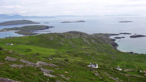 pan down from atlantic ocean to remote irish coastal houses, ring of kerry