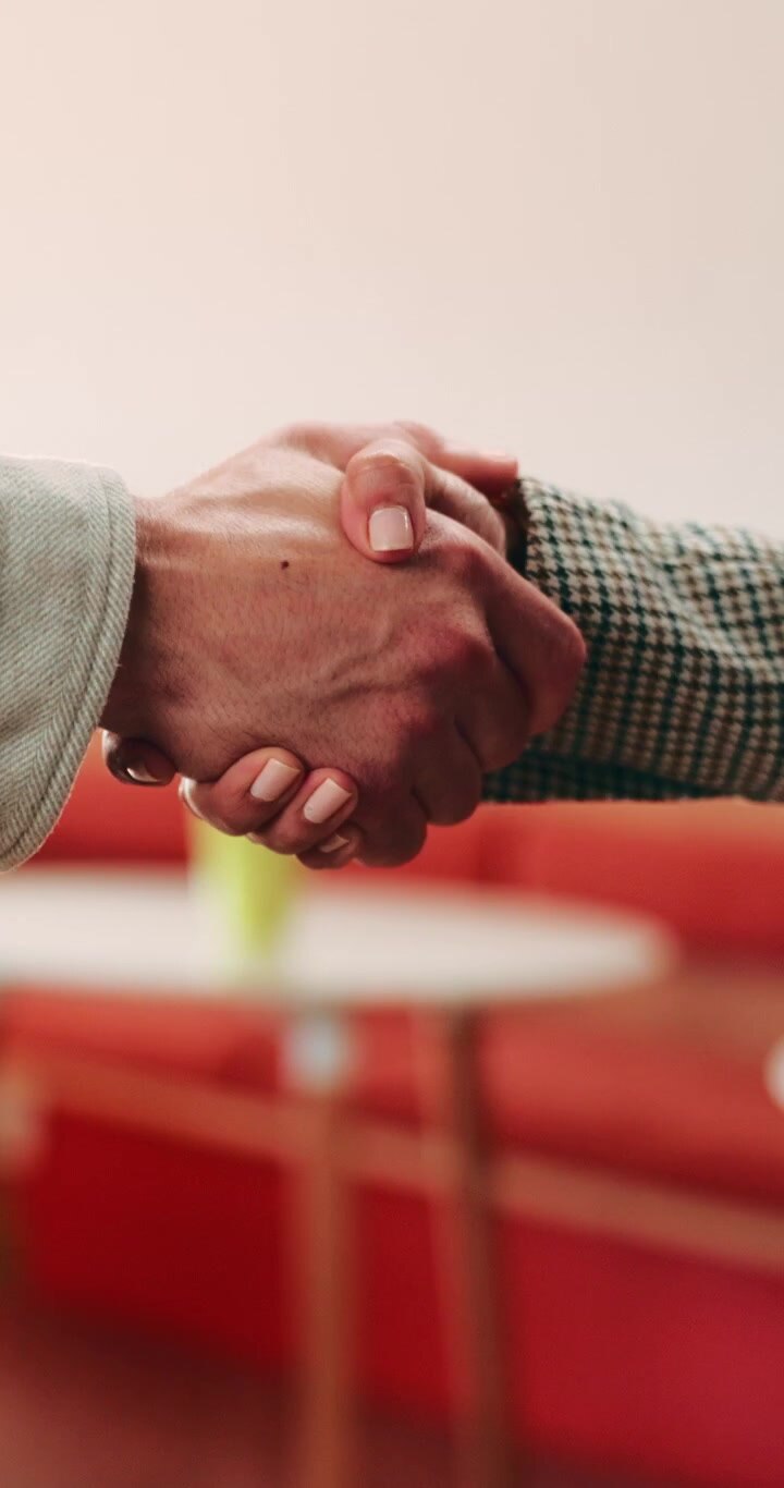 Due professionisti d'affari che si stringono la mano in un moderno ufficio