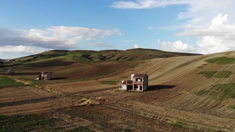 Drone-Vuela-Dejando-Granjas-Y-Revelando-El-Panorama-De-Las-Colinas-Del-Campo-De-Puglia-A-La-Hora-Dorada