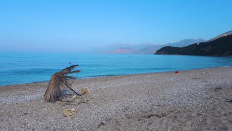 lonely shore: abandoned beach umbrella at lukova after the bustle of summer vacation in albania