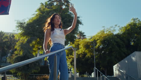 Chica-Turista-Posando-En-Las-Escaleras-Del-Parque.-Una-Mujer-Asiática-Despreocupada-Se-Hace-Selfie-Al-Caminar.