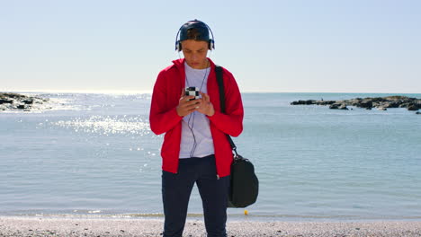 Headphones,-phone-and-teenager-at-the-beach