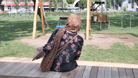a woman sitting on a bench in a park