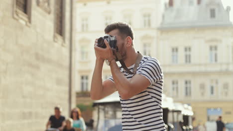 handsome man taking photos with a camera in the old town