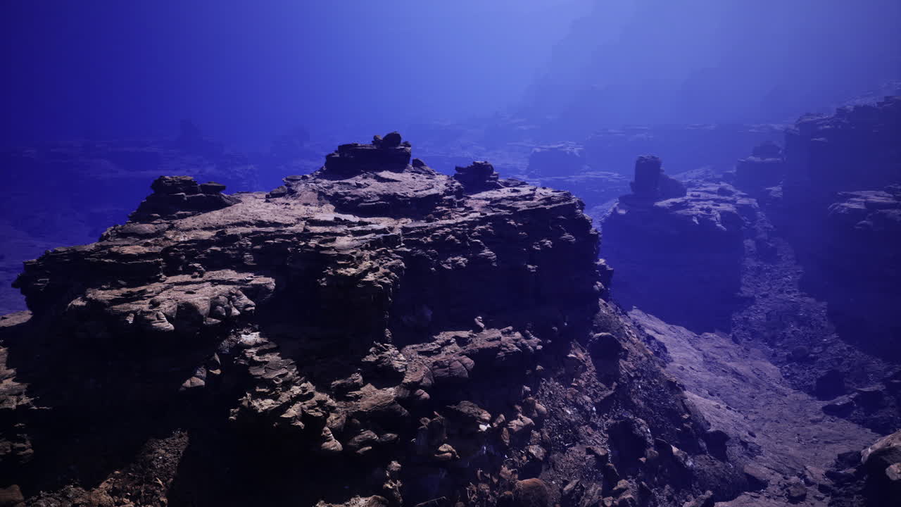 Underwater landscape reveals submerged rock formations in deep ocean
