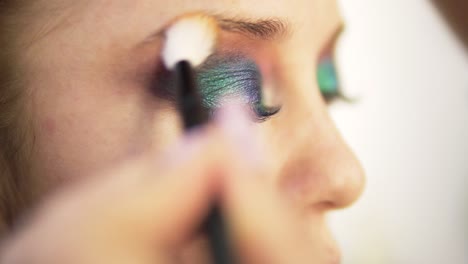 Augen-Make-up-Frau-Verteilt-Den-Lidschatten-Mit-Pinsel.-Schönes-Frauengesicht.-Perfektes-Farbenfrohes-Make-up.-Nahansicht.-Seitenansicht