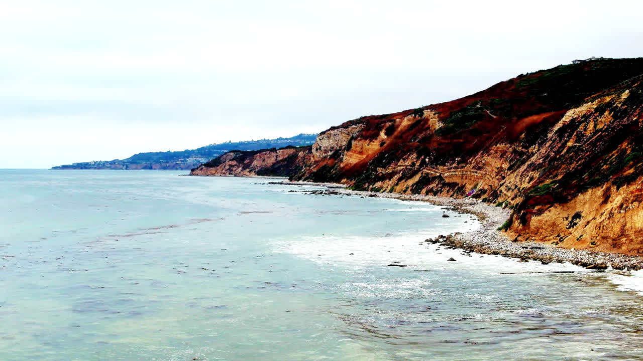 바위가 많은 남부 캘리포니아 해변에서 부서지는 파도의 하향식 조감도 공중 전망