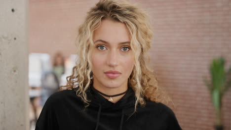 retrato de una hermosa joven rubia mirando a la cámara atractiva estudiante femenina en la universidad