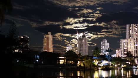 timelapse of moonrise over urban skyline and water