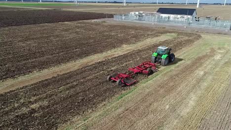 Eine-Luftaufnahme-Der-Drohne,-Wie-Sie-Einen-Traktor-Umkreist,-Der-Das-Land-Nach-Der-Ernte-Bestellt-Und-Für-Die-Nächste-Ernte-Vorbereitet