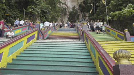 gradual rise up colorful steps and crowds leading up to batu caves, a vibrant cultural site