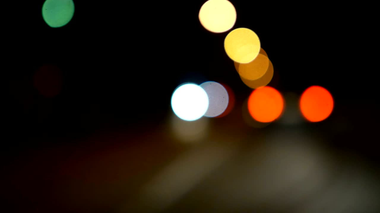 conducir un coche a través de la carretera de la noche, la autopista. luces desenfocadas calle de los ángeles resumen. ciudad fondo borroso. movimientos círculos bokeh de tráfico nocturno.