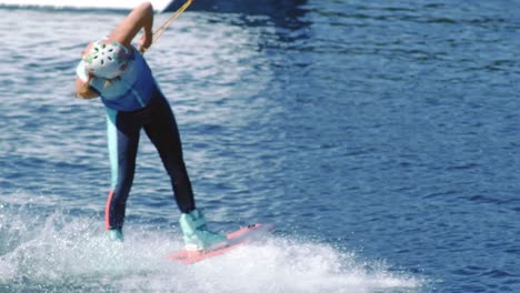 young woman riding wakeboard on summer river. entertainment on water of river