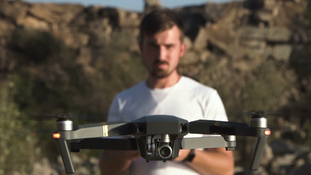 Man operating a drone in a rocky outdoor setting