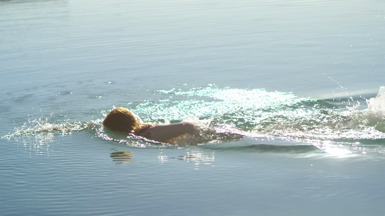 해변 4k에서 물에서 수영하는 여자