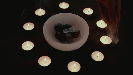 smudging crystals with palo santo during a candle magick ritual