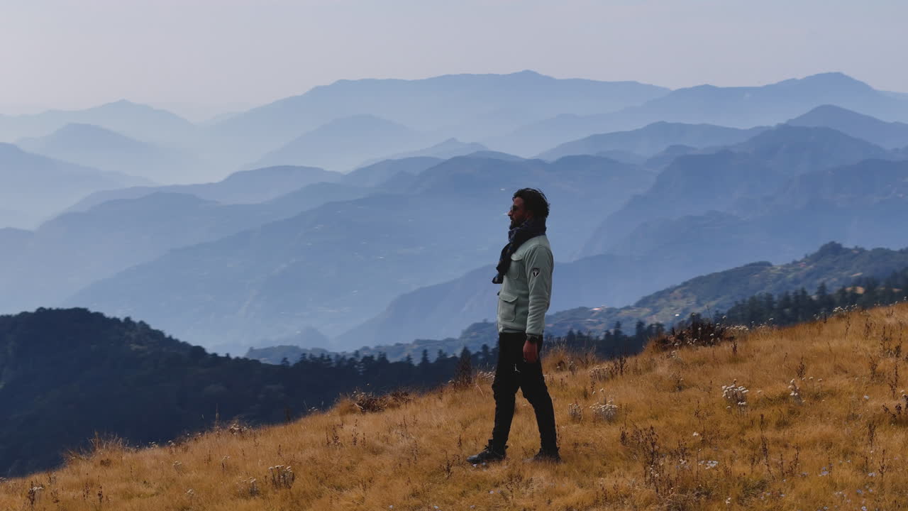 A drone shot of male tourist is amazed by the view from hilly range in Nepal noticing details of serene beauty of nature