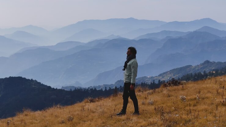 A drone shot of male tourist is amazed by the view from hilly range in Nepal noticing details of serene beauty of nature