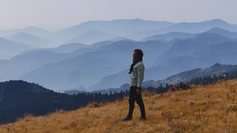 a drone shot of male tourist is amazed by the view from hilly range in nepal noticing details of serene beauty of nature