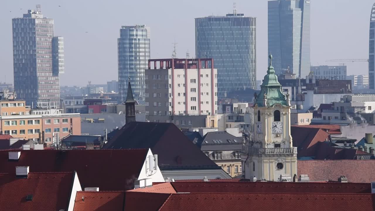 Panoramic view of Bratislava’s old town clock tower with modern skyscrapers rising in the background, Slovakia