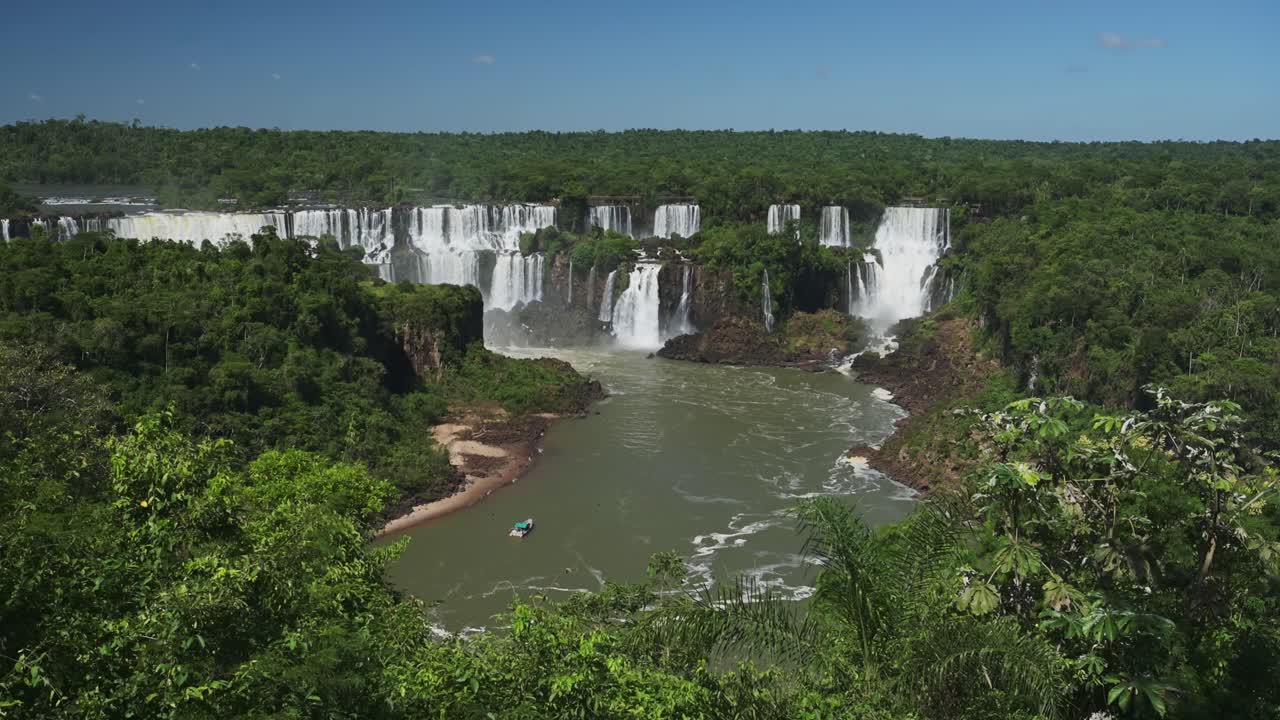 hermoso punto de vista desde altos árboles verdes que muestran cascadas pintorescas ocultas en las cataratas de iguacú, argentina, barco mirando el enorme paisaje de cascadas escondido en la selva argentina