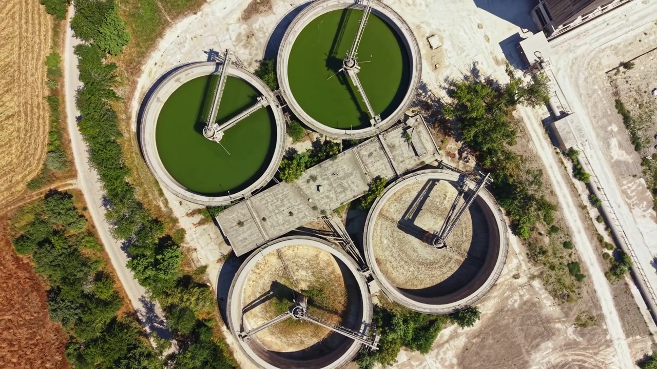 Water treatment facility with circular tanks located in a rural area during daylight showing different stages of water processing