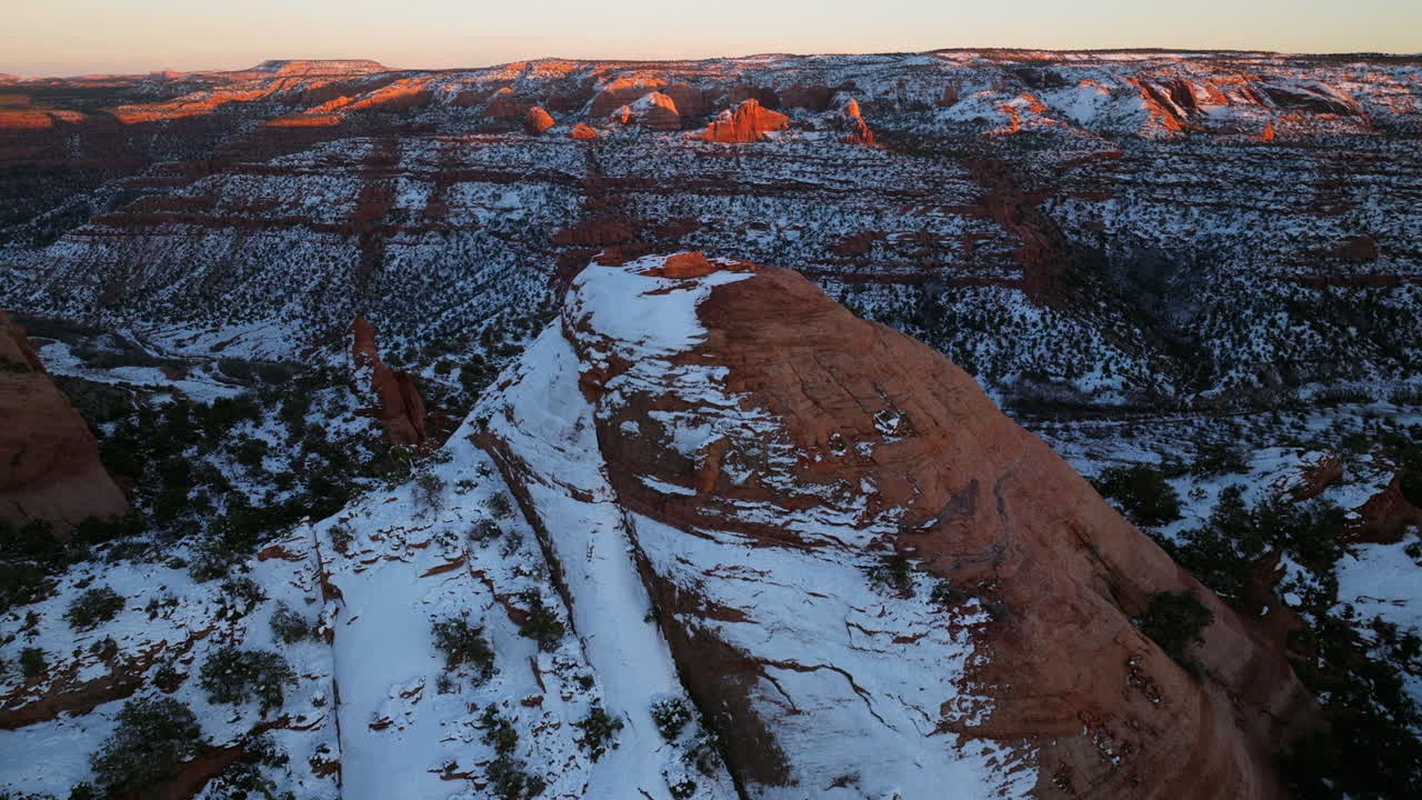 disparo de avión no tripulado volando sobre la formación de roca roja cubierta de nieve