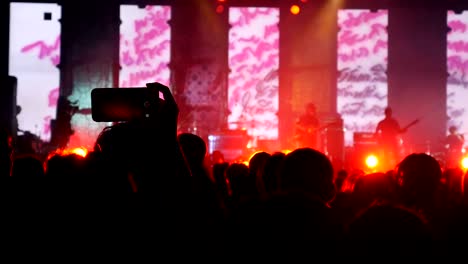 people holding smart phone recording video group of people dancing music festival.