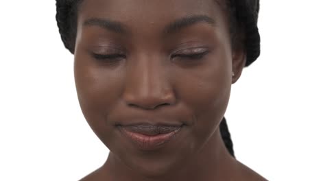 retrato en primer plano de una joven africana mirando a la cámara y asintiendo con la cabeza con una sonrisa. aislada sobre un fondo blanco